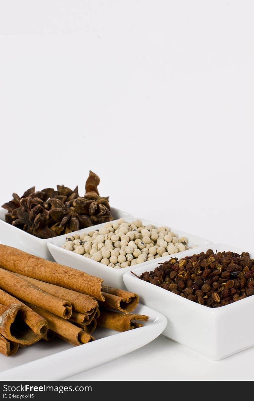 Star Anise, Cinnamon, White Pepper and Coriander Seed in Ceramic Bowl on White Background. Star Anise, Cinnamon, White Pepper and Coriander Seed in Ceramic Bowl on White Background