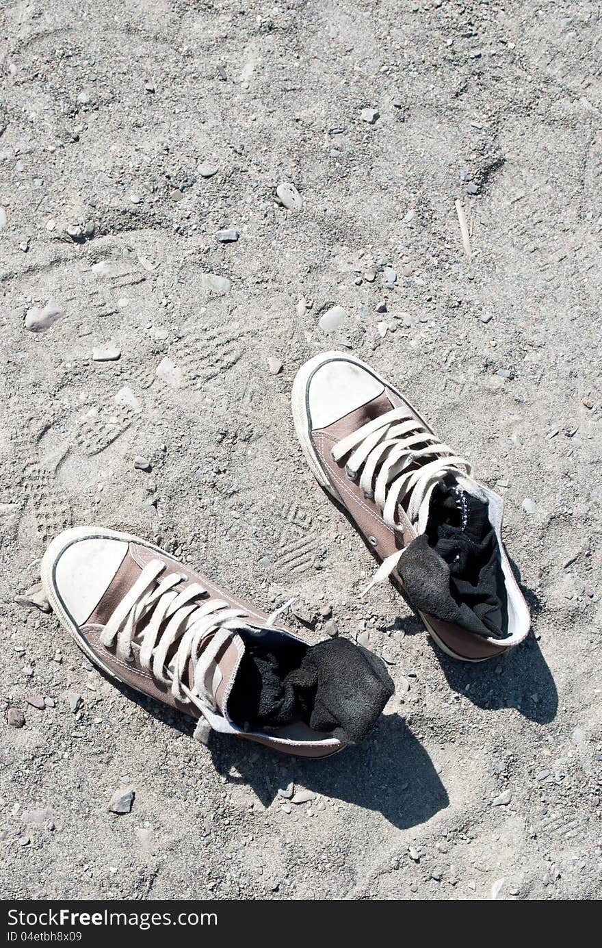 Pair of shoes kept in the sand