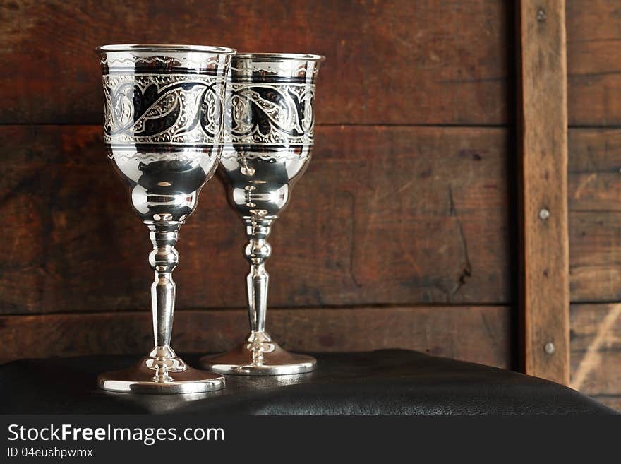 Pair of nice vintage silver goblets on old wooden background