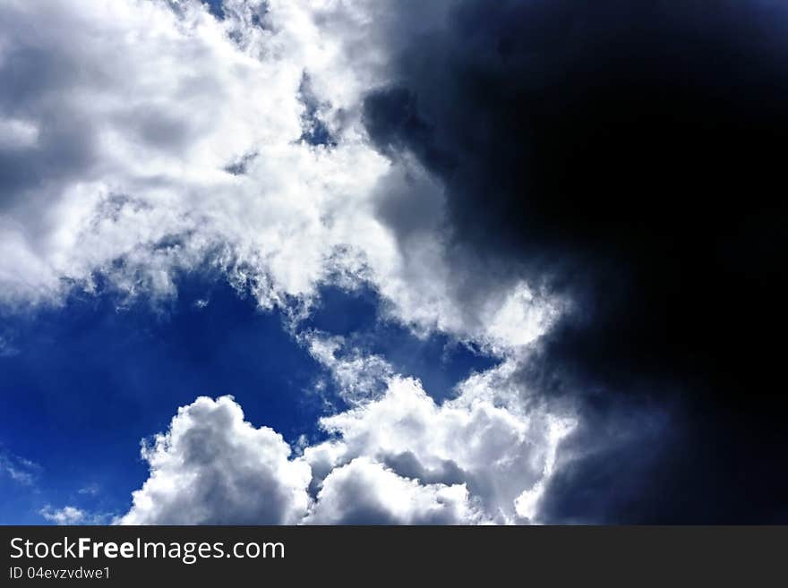 A blue sky with lighten white and dark black clouds. A blue sky with lighten white and dark black clouds