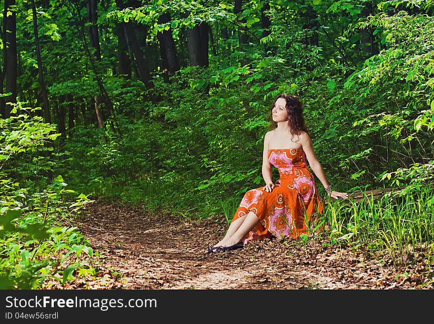 Woman Sitting In Forest