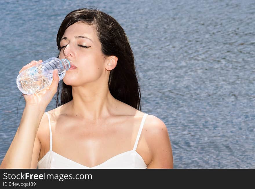 Woman drinking water to quench the thirst on a hot summer day. Woman drinking water to quench the thirst on a hot summer day.