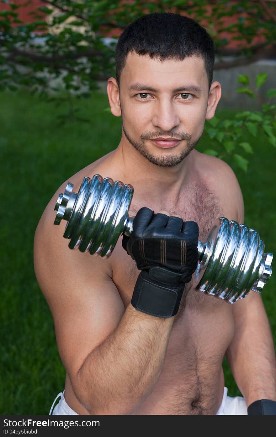 Portrait of young man holding dumbbell outdoors. Portrait of young man holding dumbbell outdoors