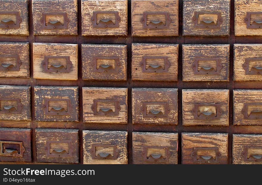 Close-up of a bank of worn wooden file card drawers. Suitable for background. Close-up of a bank of worn wooden file card drawers. Suitable for background.