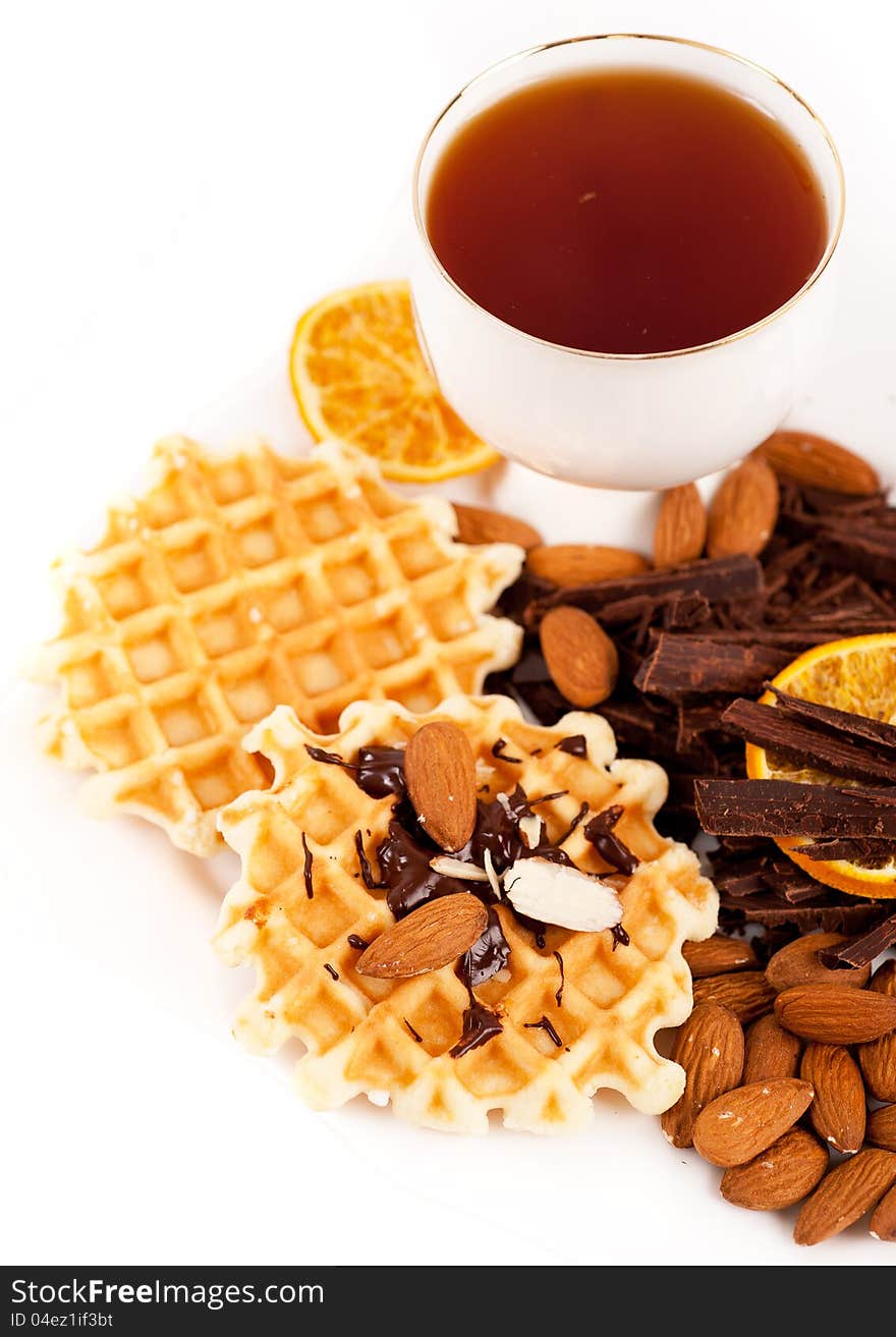 Sweet waffles with chocolate, nuts and a cup of te