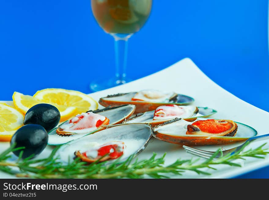 A dish with mussels with sauce bechamel with olives, lemon and rosemary. A dish with mussels with sauce bechamel with olives, lemon and rosemary