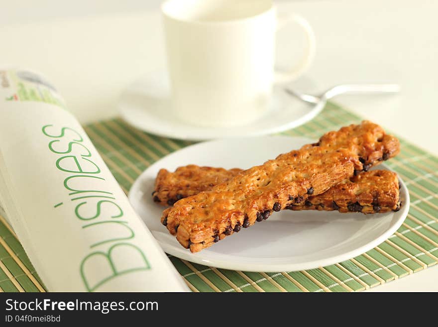 Cup coffee pastry chocolate chips and whitebackground