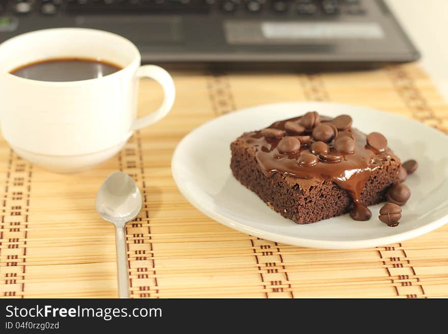 Chocolate cake and a coffeecup lab top. Chocolate cake and a coffeecup lab top