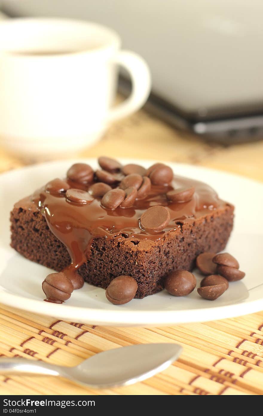 Chocolate cake and a coffeecup lab top. Chocolate cake and a coffeecup lab top