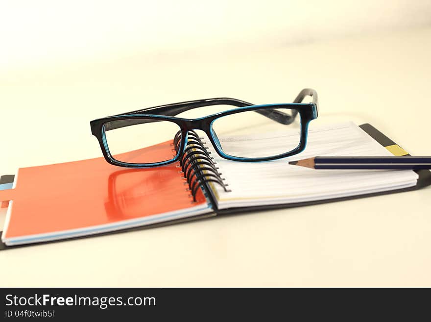 Black notebook cover Glasses and a pencil