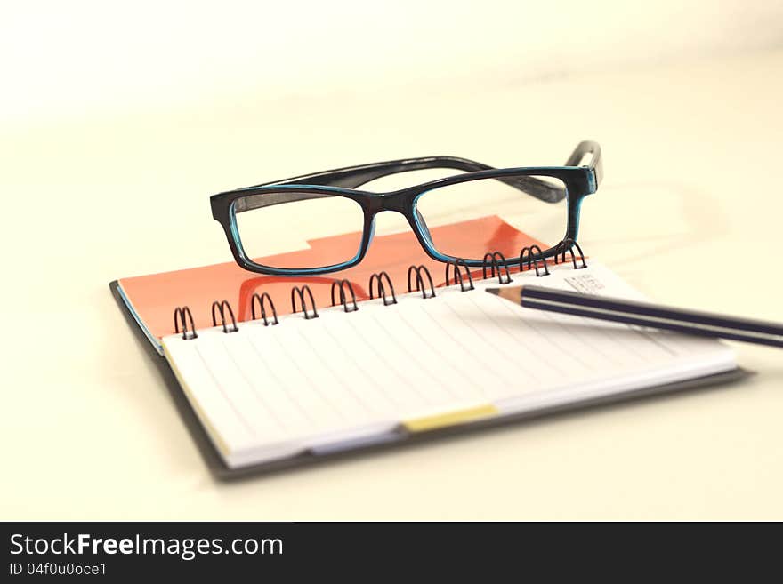 Black notebook cover Glasses and a pencil