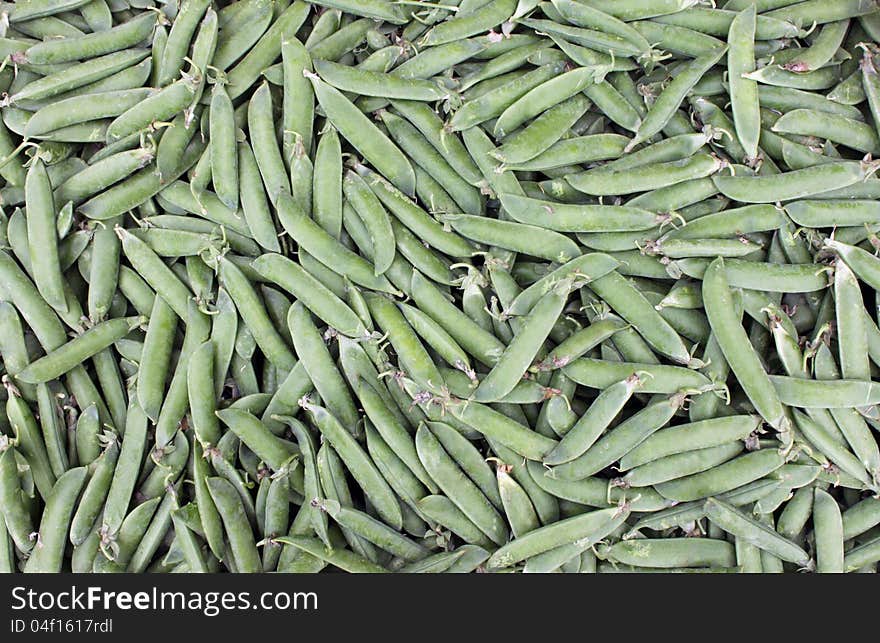 Pea pods for the preparation of meals at a market stand.