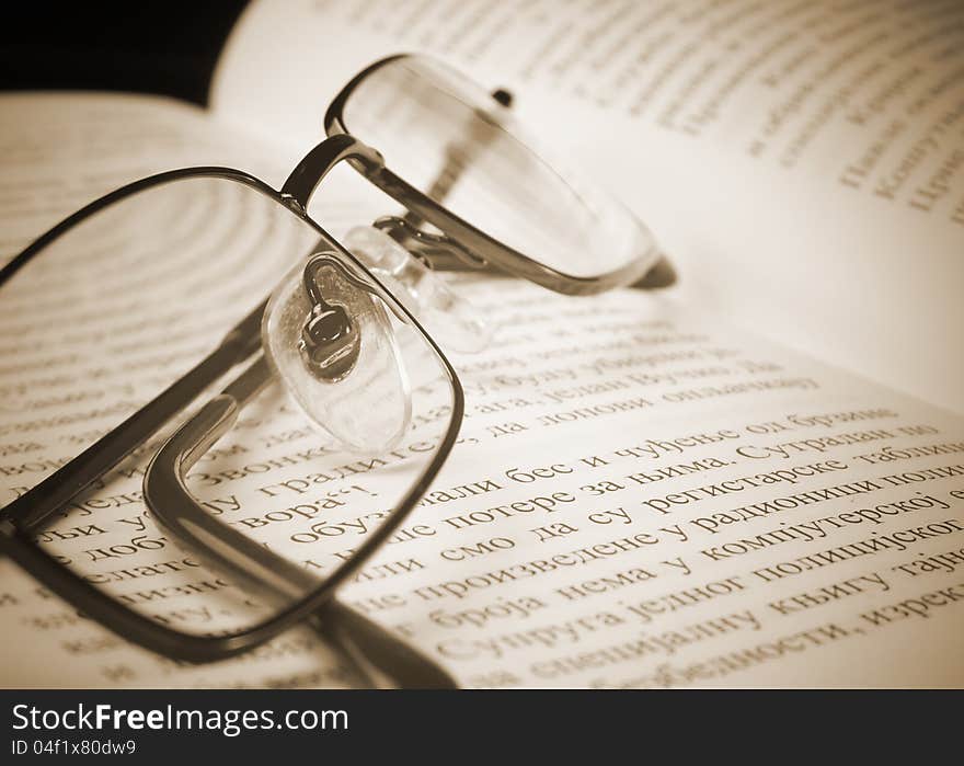 Eyeglasses on the old thick book. A photo close up