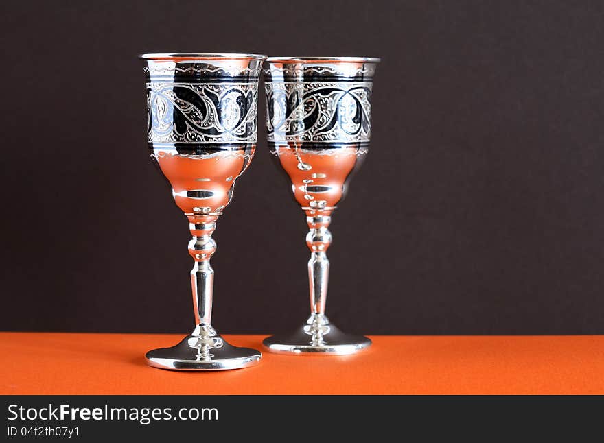 Pair of nice vintage silver goblets on ginger and dark background