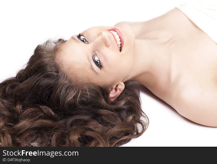 Happy woman with curly hair lying on the floor