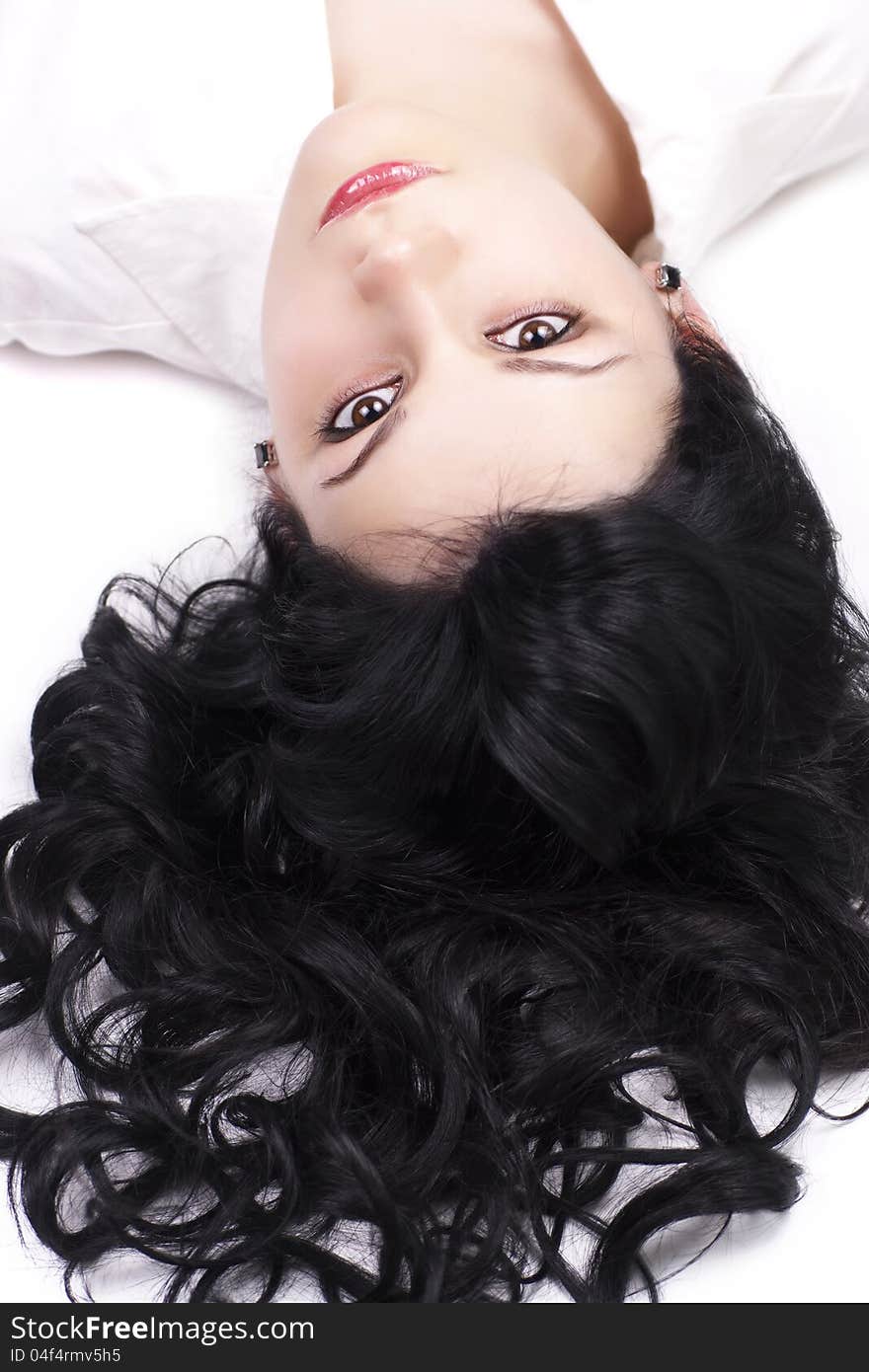 Closeup portrait of sensual young brunette woman posing while lying on floor