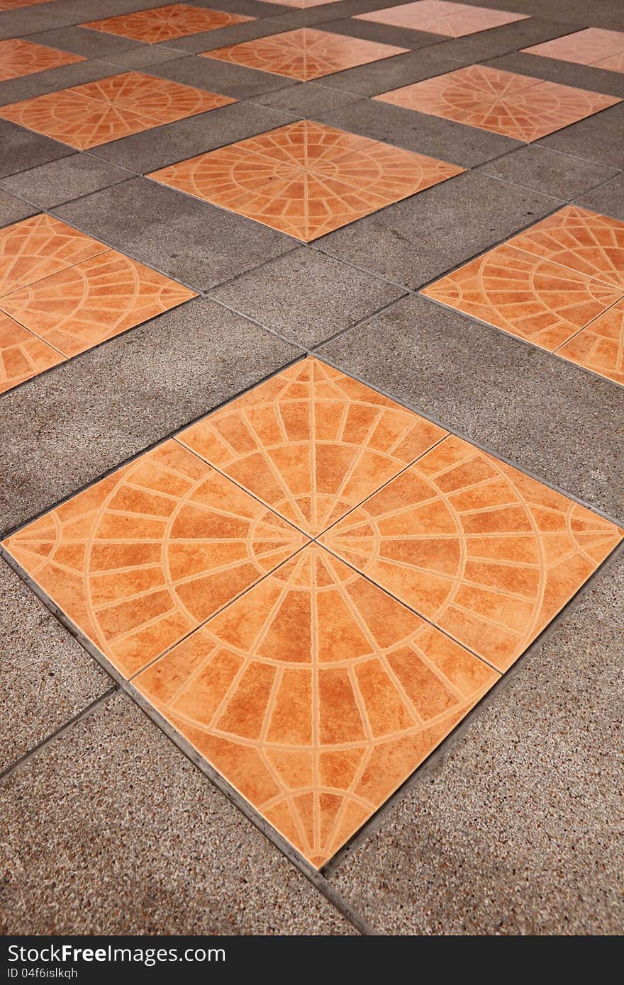 Orange square tiles on the pavement.