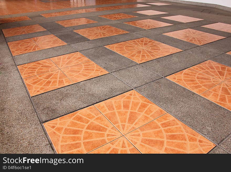 Orange square tiles on the pavement.