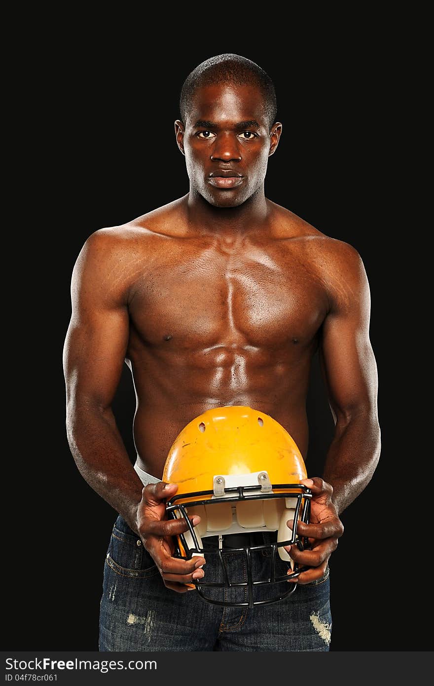 Young African American Man holding a Football Helmet isolated on a dark background