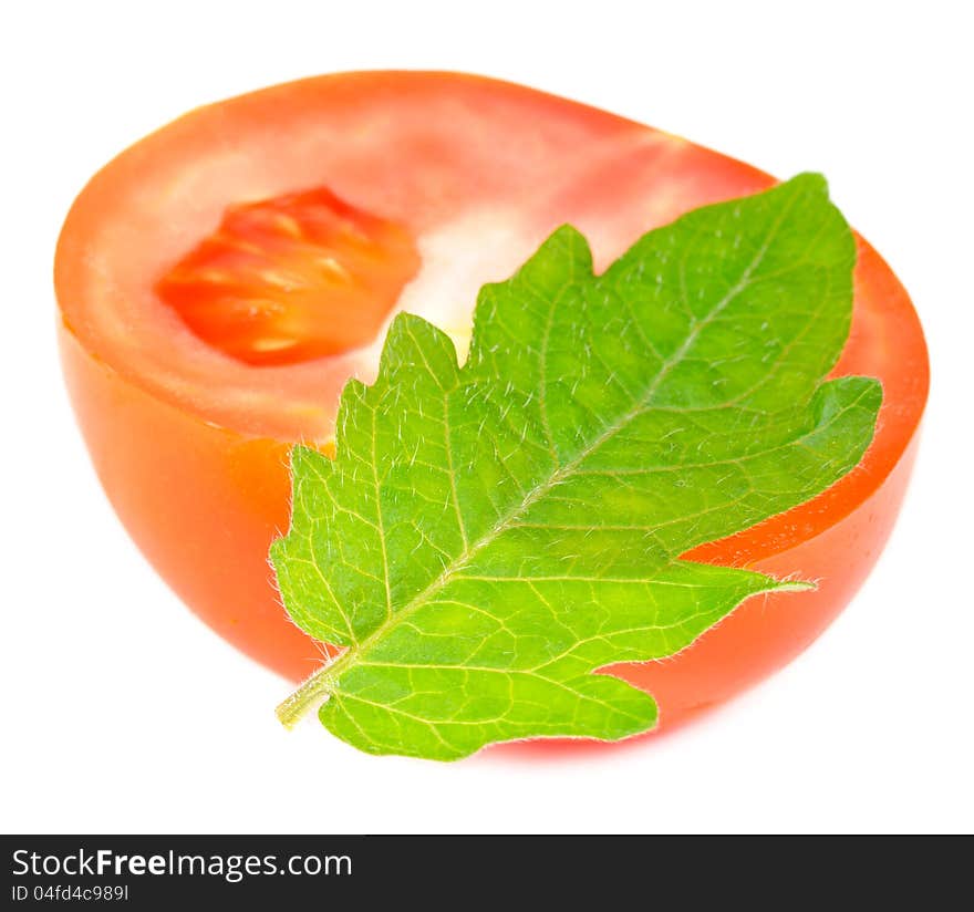 A half of red tomato with a green leaf on a white background. A half of red tomato with a green leaf on a white background