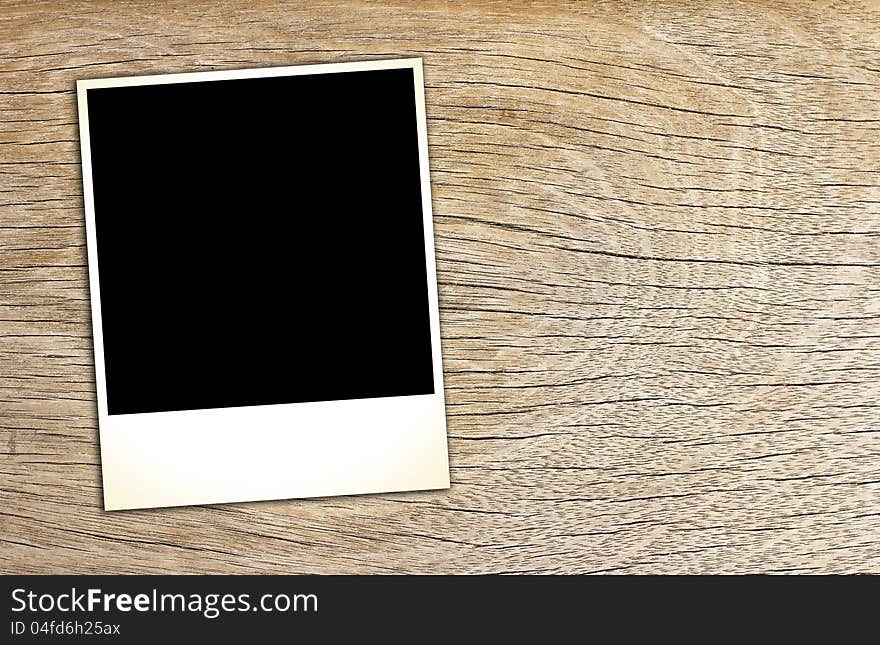 Blank vintage paper and photo frame on wooden background