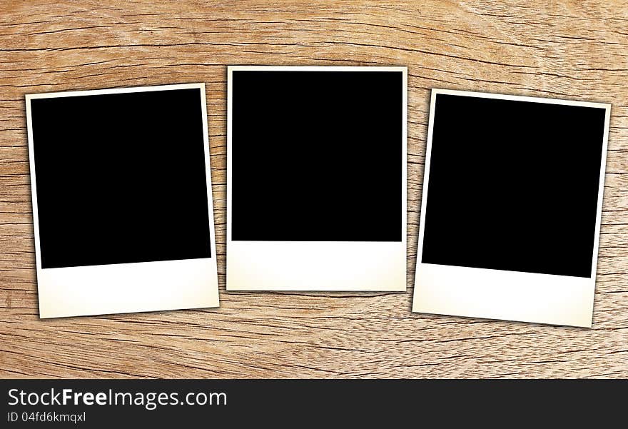 Blank vintage paper and photo frame on wooden background