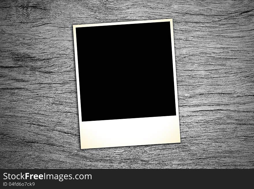 Blank vintage paper and photo frame on wooden background