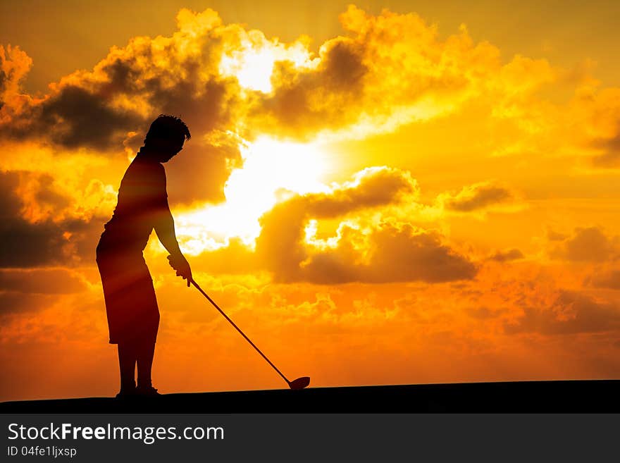 Image of Silhouette golfer at sunset