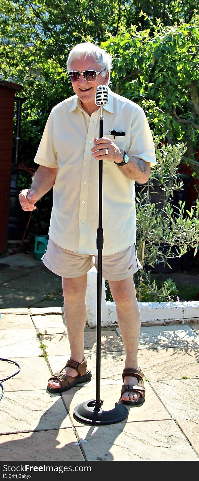 Photo of a pensioner having fun as a 1950's karaoke crooner.