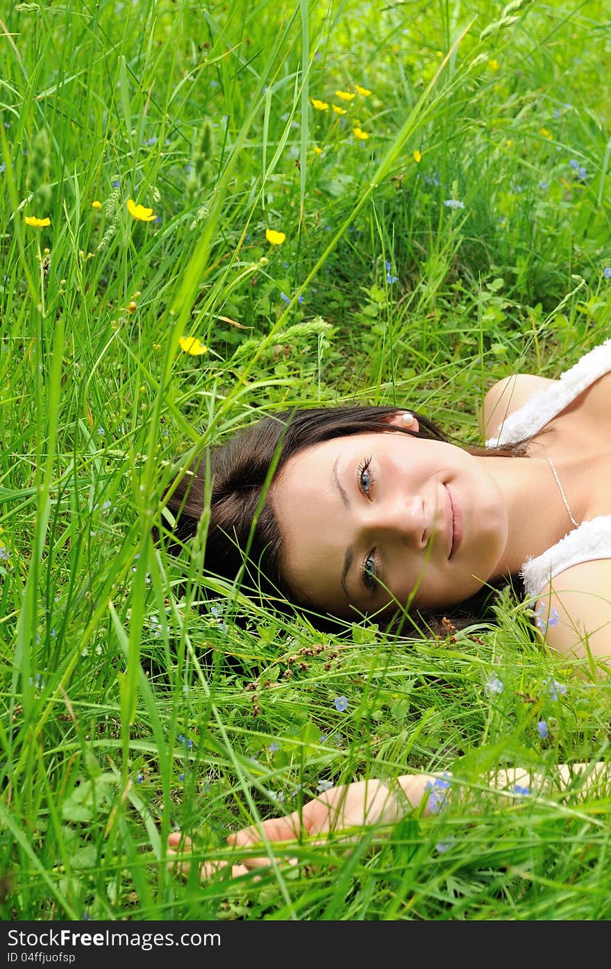 Girl lying on green grass and looking to the camera. Girl lying on green grass and looking to the camera