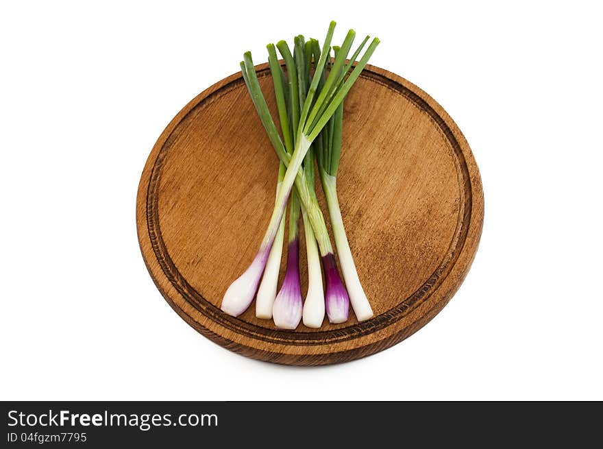 Spring onions on a wooden mat