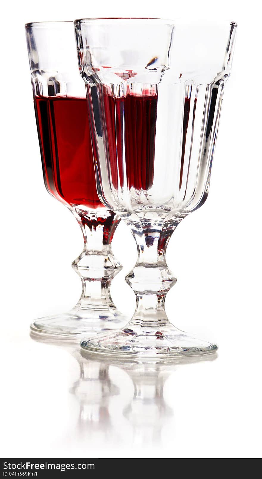 Glass of red wine and empty glass with reflection on a white background. Glass of red wine and empty glass with reflection on a white background.