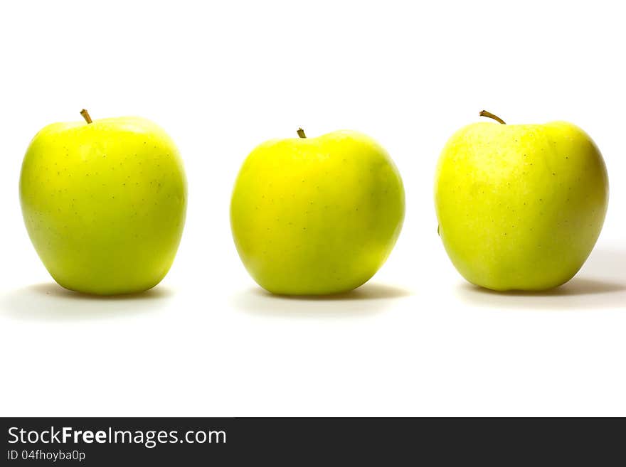 Three yellow-green apples in a row  on white background. Three yellow-green apples in a row  on white background.