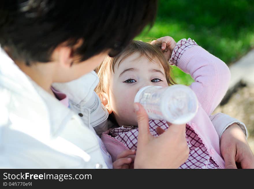 Mother Feeding Her Baby Girl With Feeding Bottle