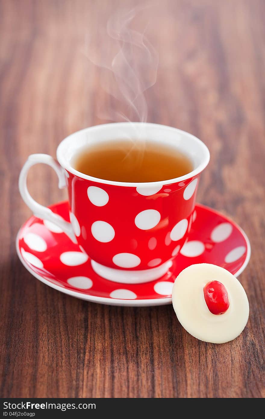 Cup of hot tea and white chocolate cranberries candy, selective focus. Cup of hot tea and white chocolate cranberries candy, selective focus