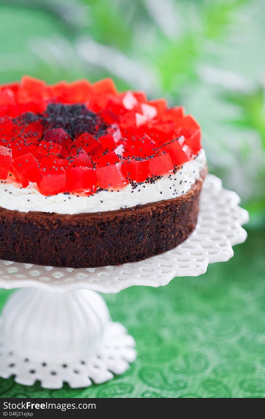 Poppy seeds and chocolate cake with red jelly, selective focus