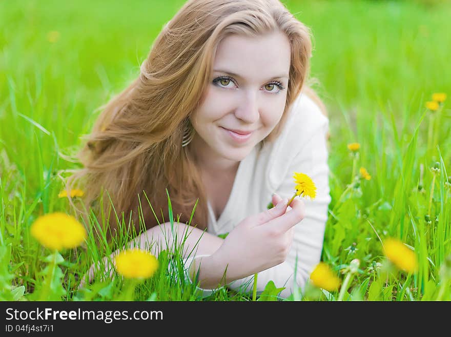 Girl on yellow dandelion on green field. Girl on yellow dandelion on green field