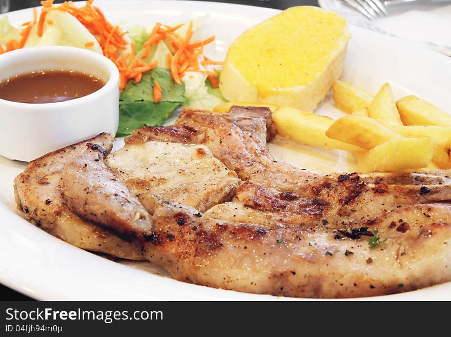 Delicious grilled pork chop in white dish