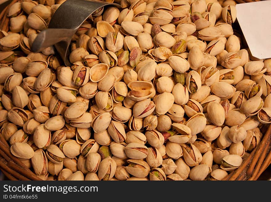 Many pistachios lie in a wattled basket in the market. Many pistachios lie in a wattled basket in the market.