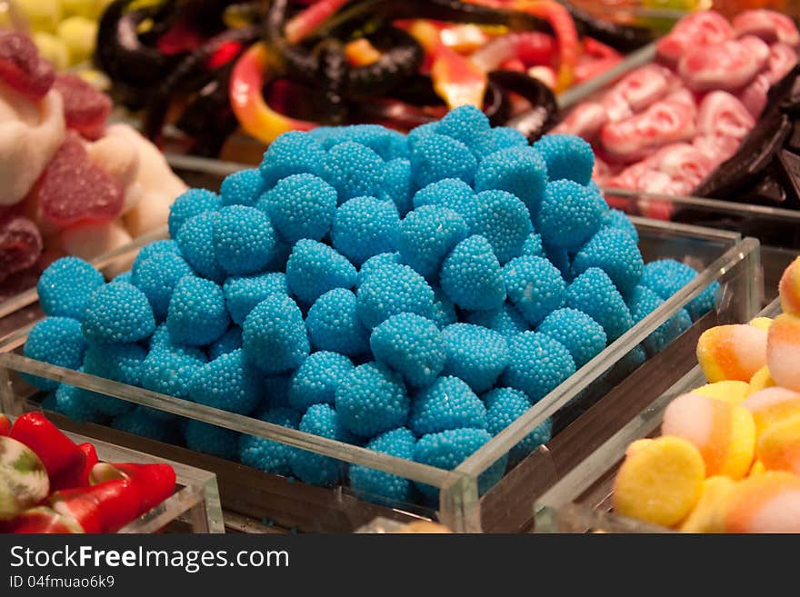 There are blue fruit candy on a show-window. There are blue fruit candy on a show-window