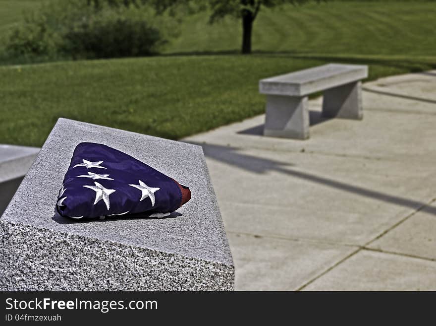 Folded American flag on memorial stone. Folded American flag on memorial stone