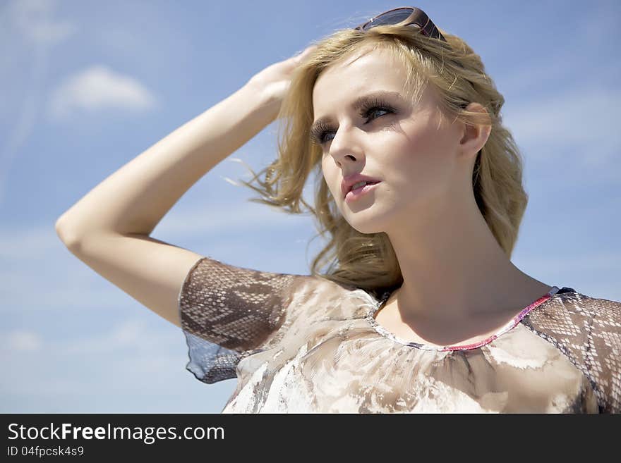 Portrait of beautiful blonde girl in sunglasses on background blue sky. Portrait of beautiful blonde girl in sunglasses on background blue sky