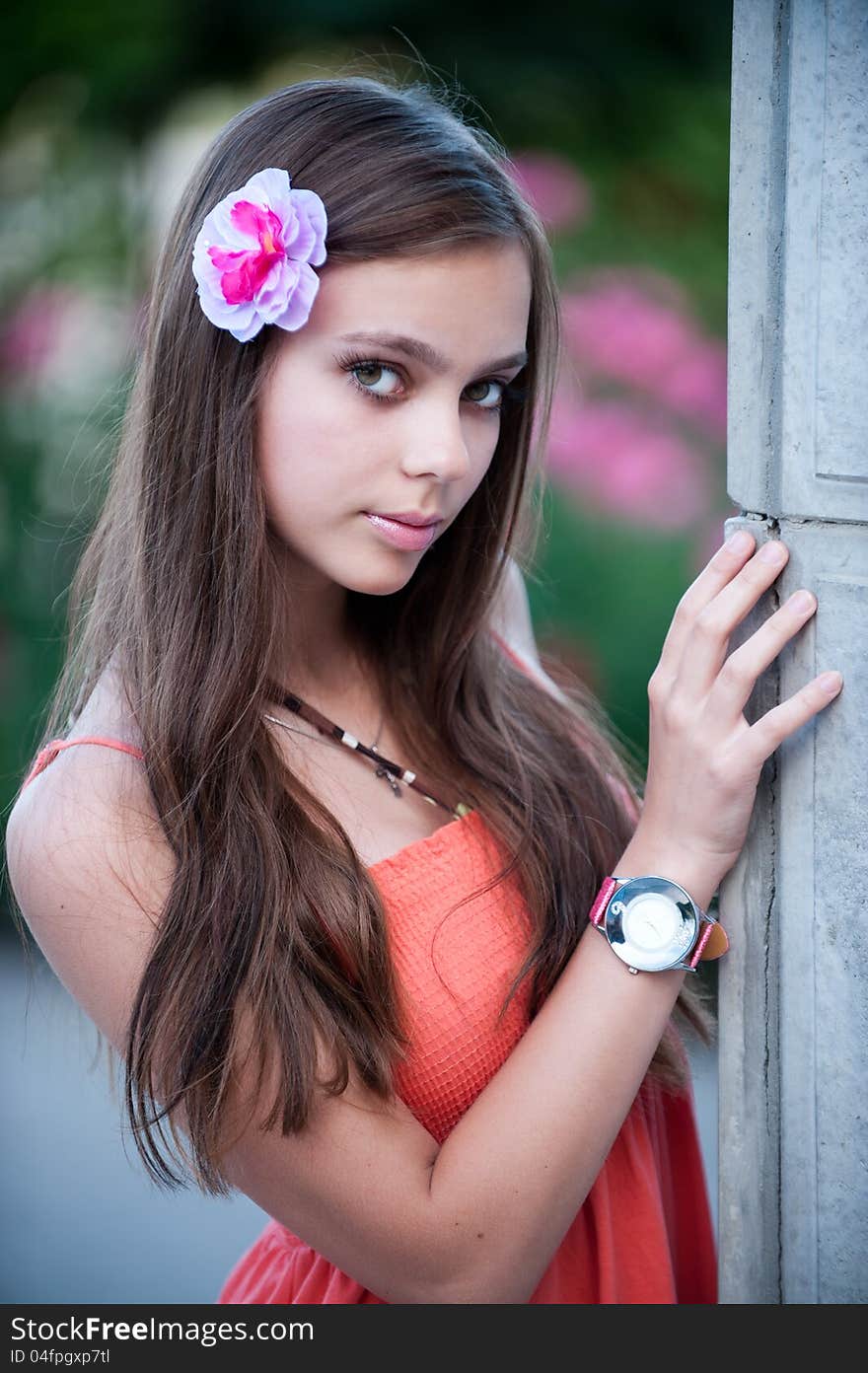 Portrait of beautiful fresh teenager girl with expressive look posing on a background of flowerbeds. Portrait of beautiful fresh teenager girl with expressive look posing on a background of flowerbeds