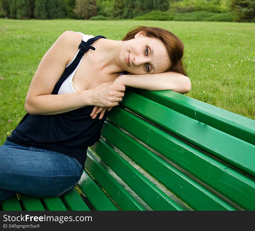 Beautiful girl sitting on a bench and sad