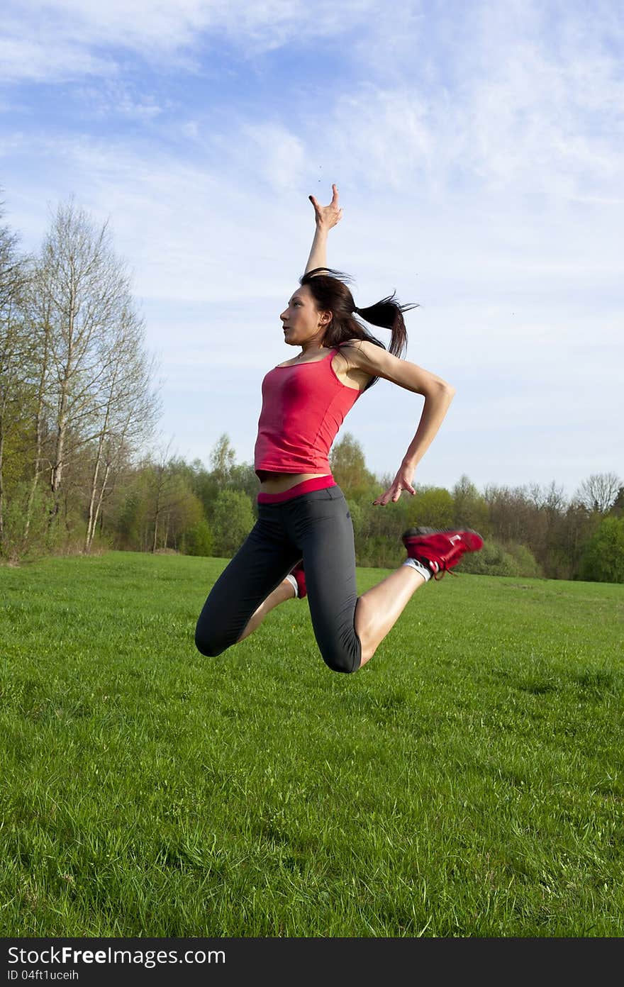 Active woman jumping in the park, outside sport shot. Active woman jumping in the park, outside sport shot