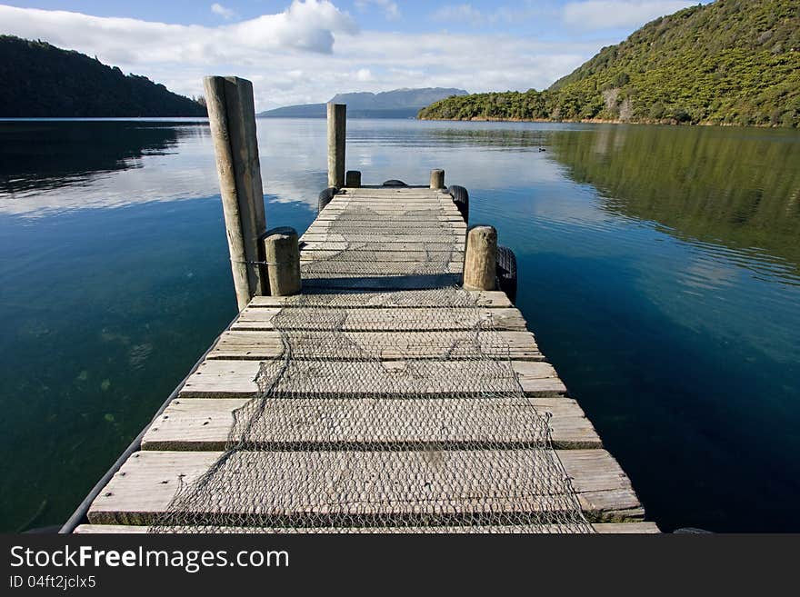 View from pier on Lake Tarawera towards Tarawera volcano and mountain on a summer morning. View from pier on Lake Tarawera towards Tarawera volcano and mountain on a summer morning