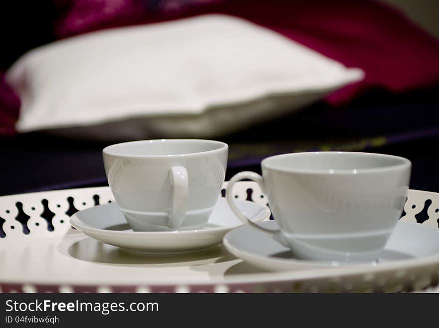 Cups with pillow on a bed