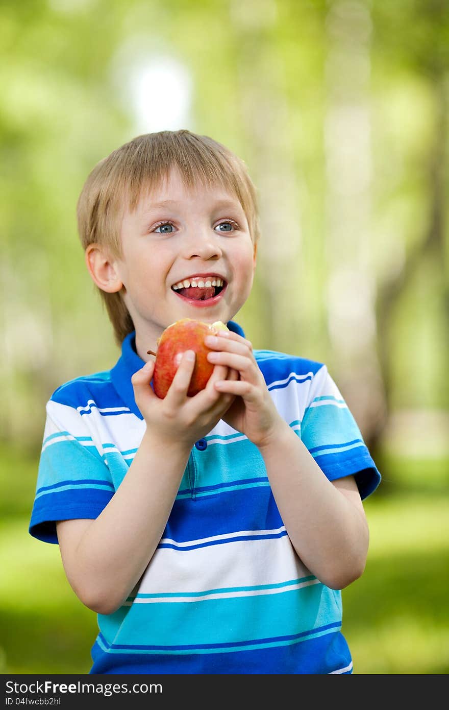 Kid holding healthy food apple outdoor