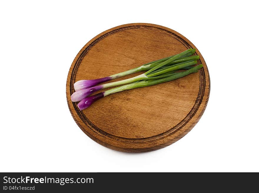 Spring red onions on a wooden mat