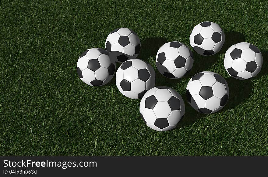 Football or soccer balls on a green lawn